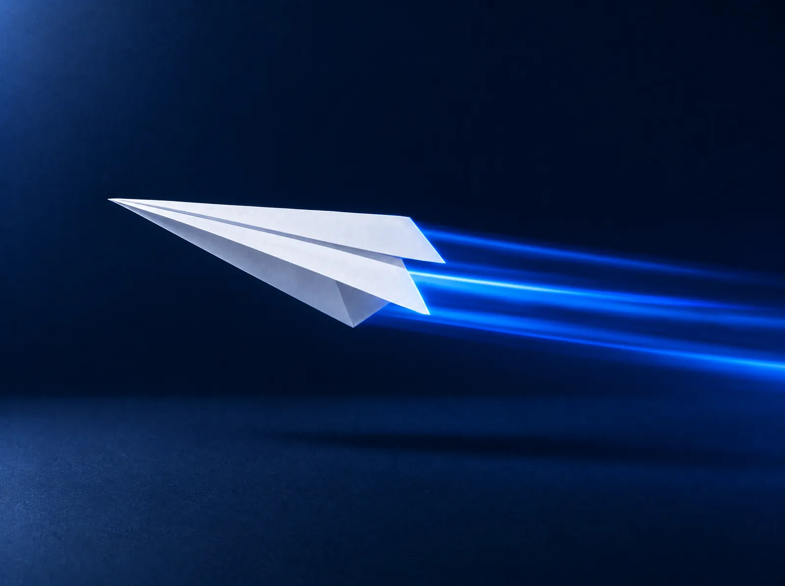 A paper airplane flying with streaks of blue light behind it.